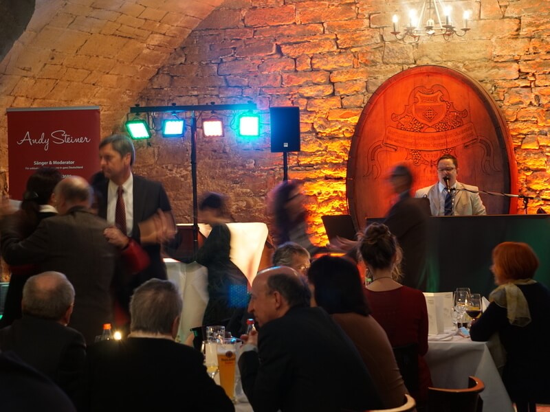 Alleinunterhalter spielt Live-Musik auf einer Geburtstagsfeier mit tanzenden Gästen